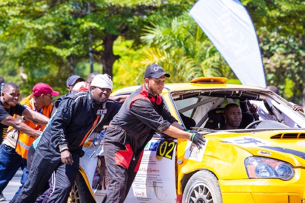 free-photo-of-group-of-men-pushing-a-car